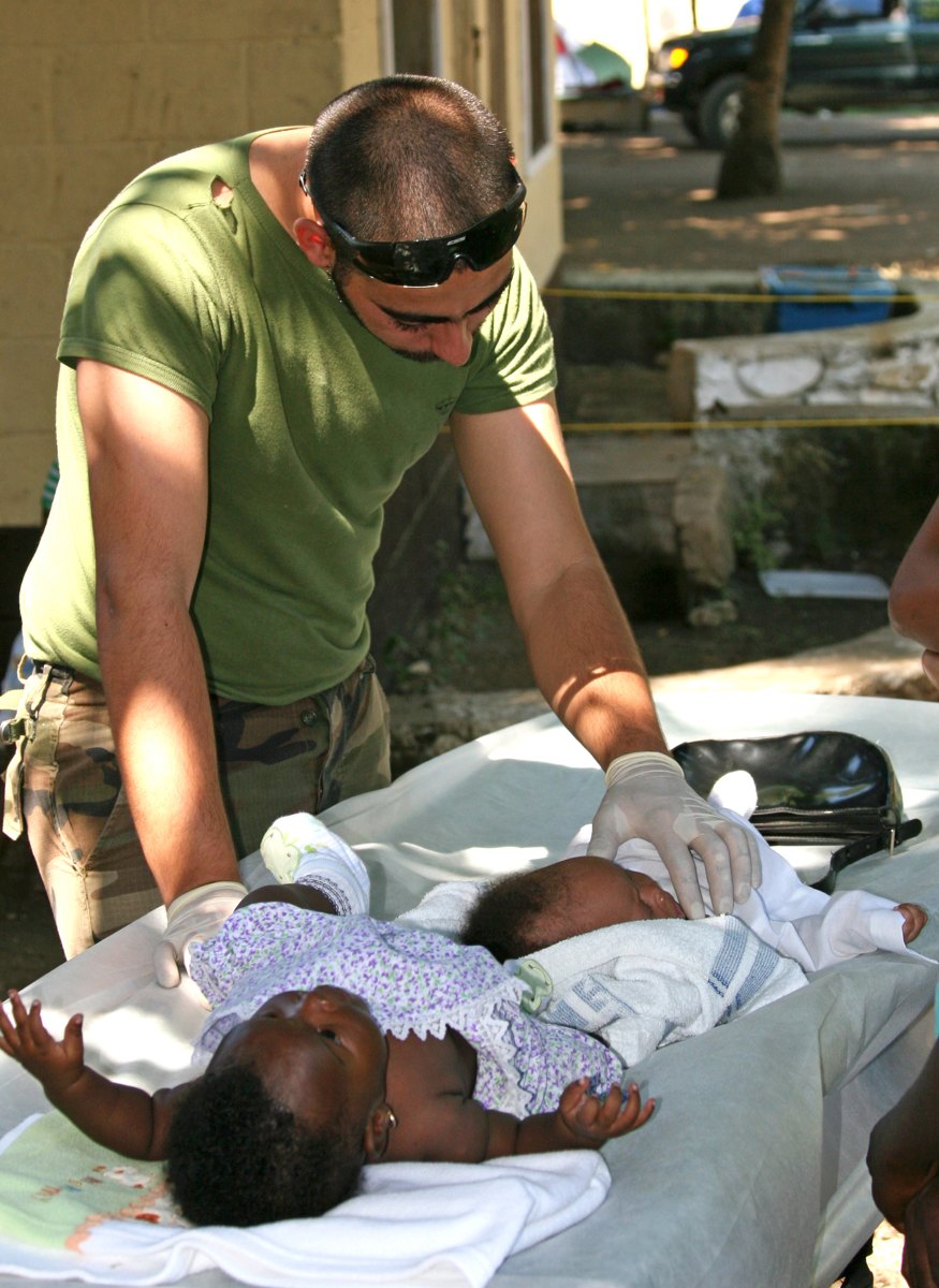 Um profissional acolhe um bebê enquanto aguarda atendimento na clínica Wesleyan Center, no Haiti.