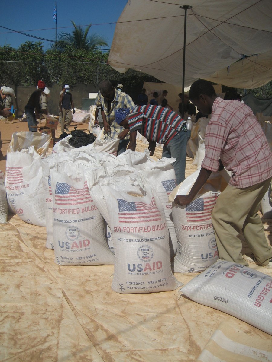 Pessoas organizam sacos de alimentos para distribuição após o terremoto no Haiti.